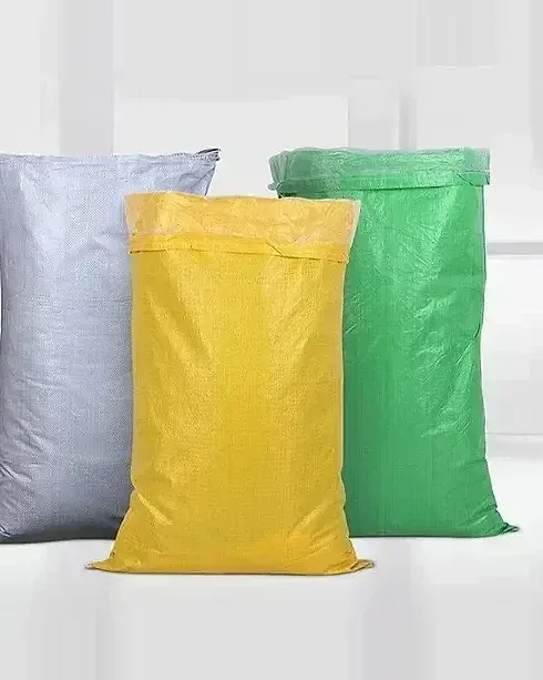Three woven bags standing side by side, grey, yellow and green, in a studio setting.